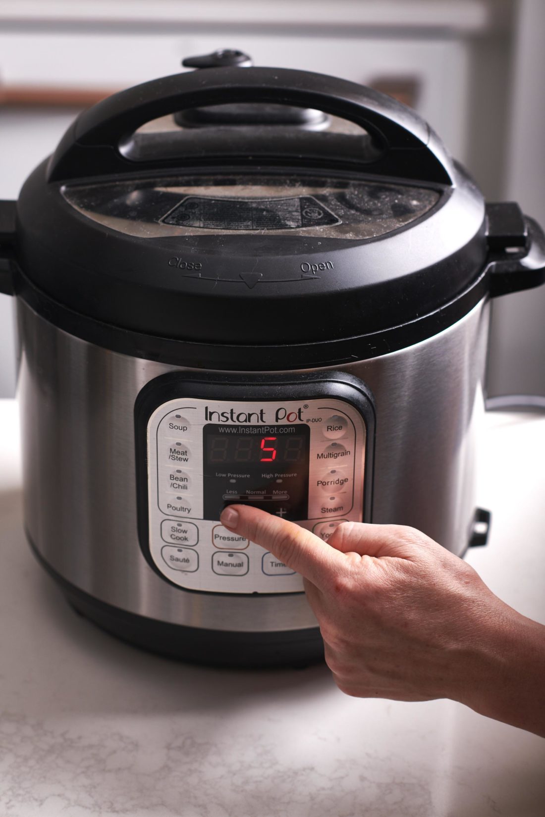 Woman setting an Instant Pot to 5 minutes.