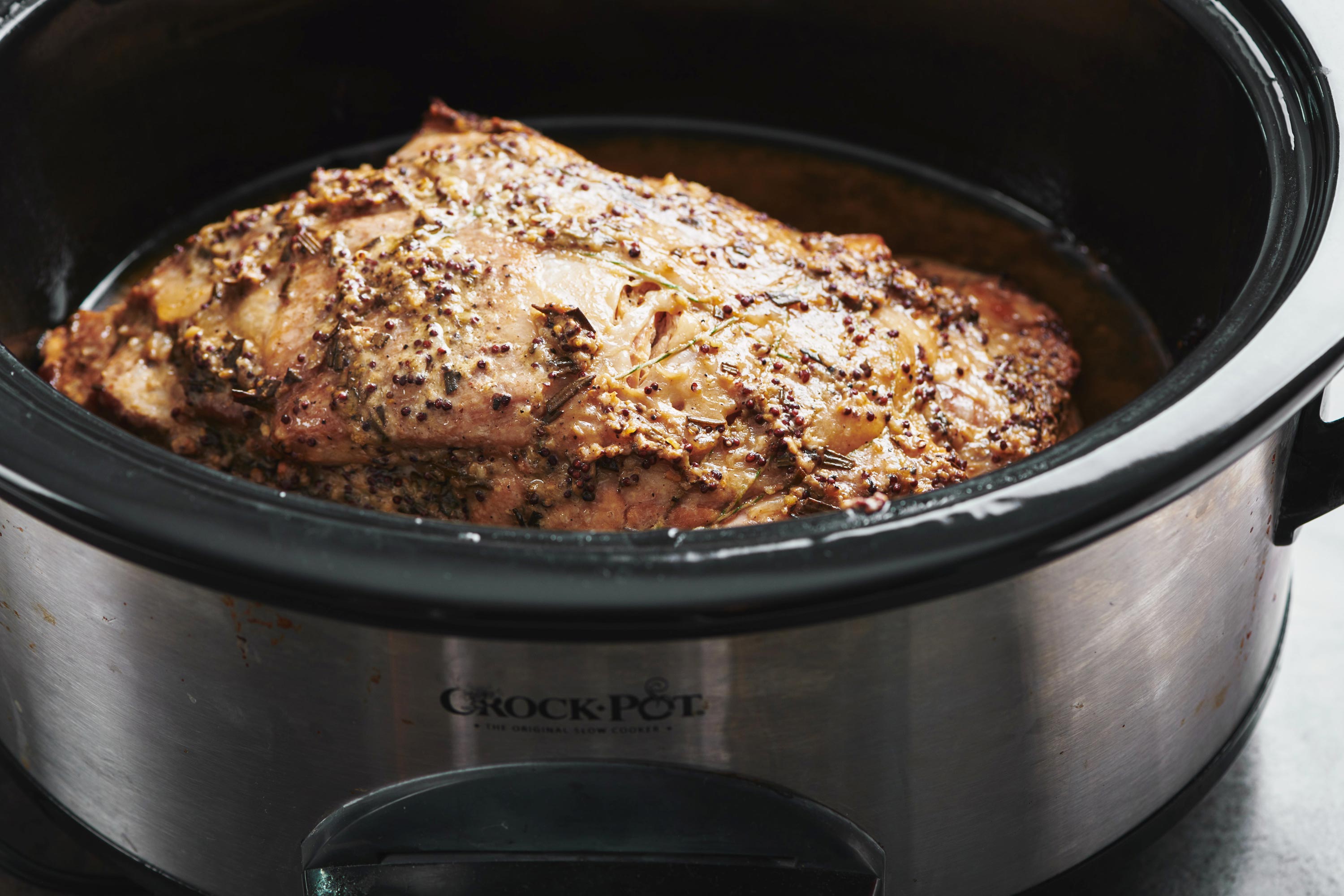 Slow Cooker Fall Apart Pork Butt with Brown Sugar, Garlic and Herbs in slow cooker.