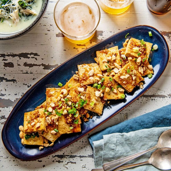 Spicy, Sweet and Nutty Tofu on a long blue platter.