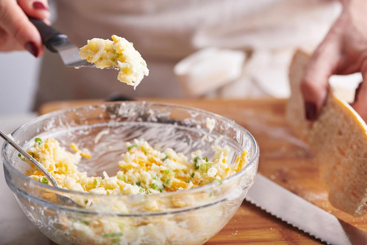 Glass bowl with a cheese, garlic, and butter mixture.