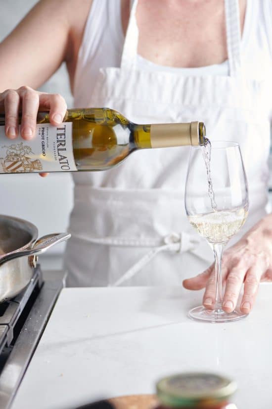 Woman pouring Terlato Pinot Grigio into a wine glass.