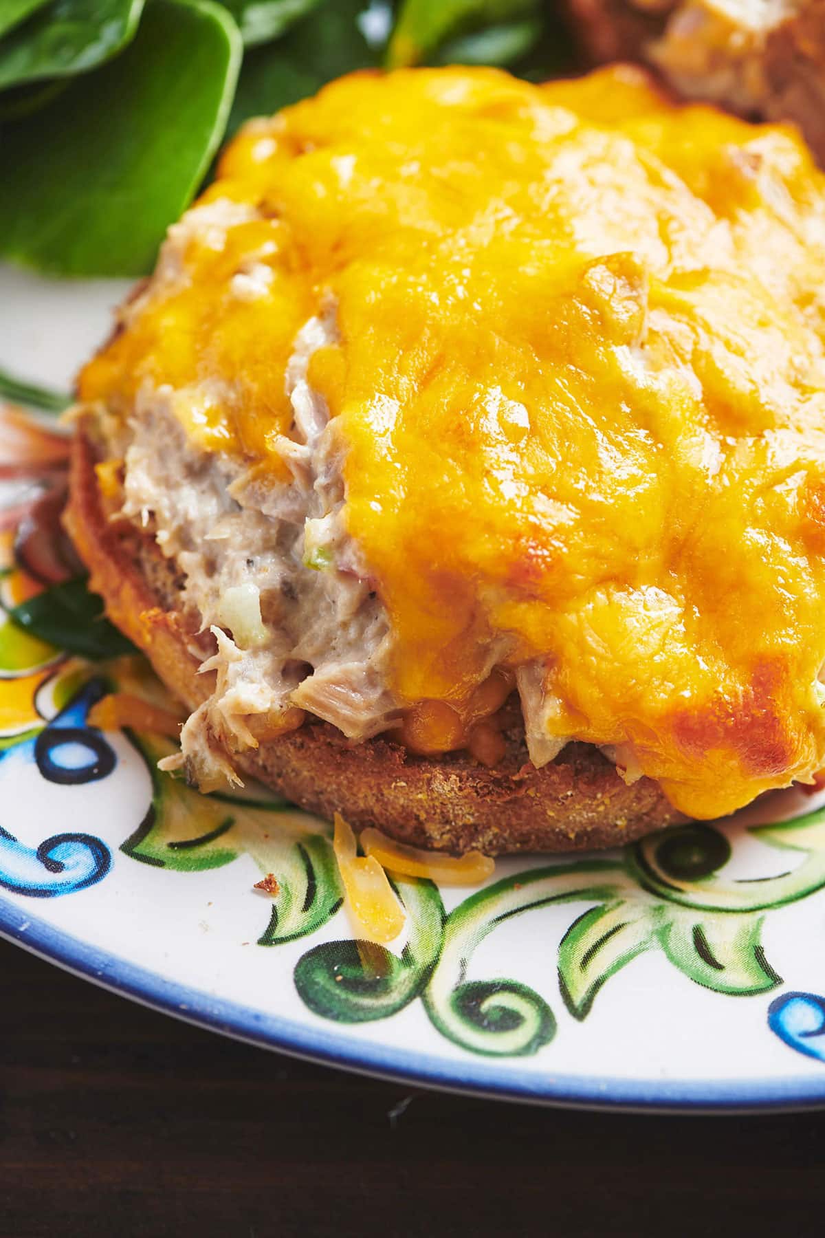Tuna melt sandwich on colorful plate.