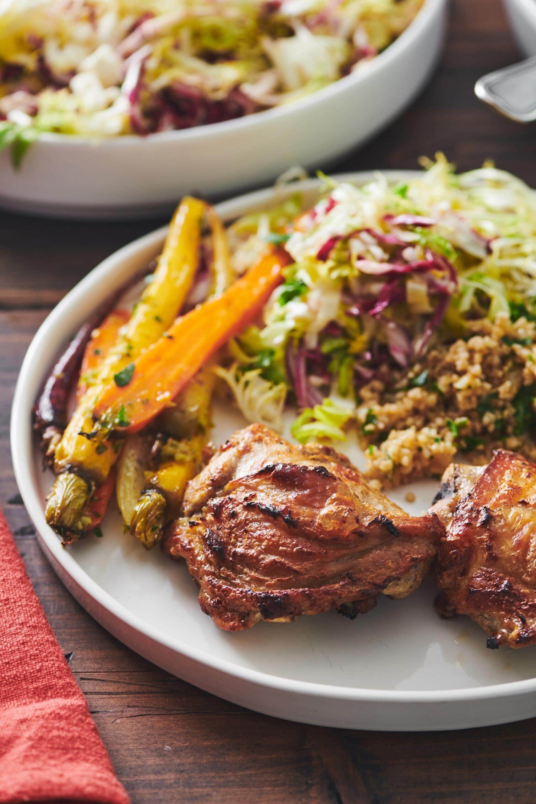 Plate of bulgur wheat, carrots, salad, and Yogurt Marinated Chicken.