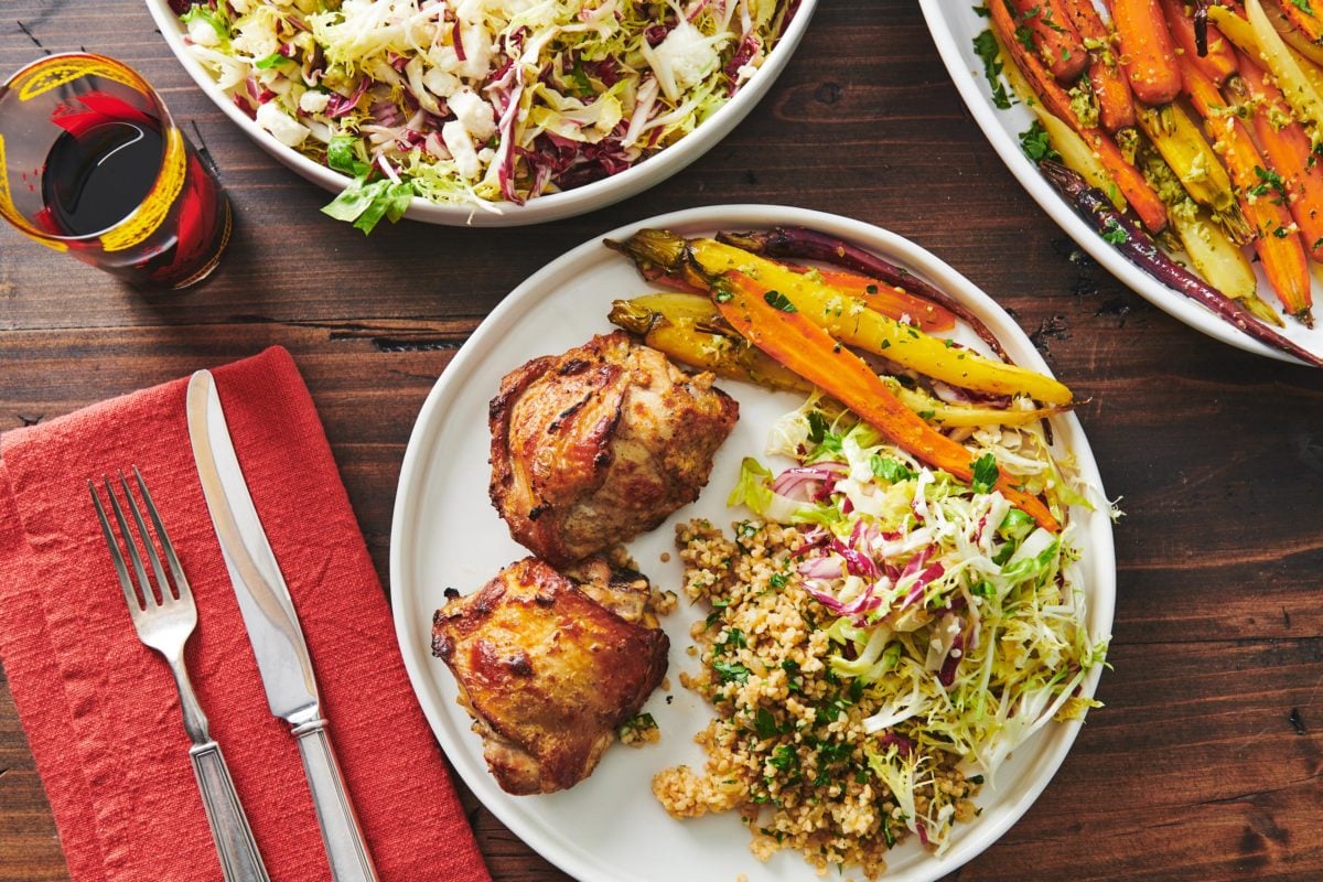 Yogurt Marinated Chicken on a plate with bulgur wheat, carrots, and salad.