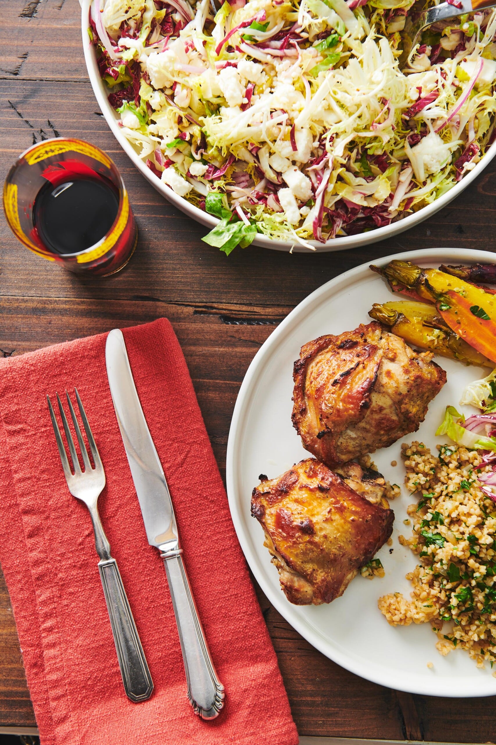 Yogurt Marinated Chicken on a plate next to a red cloth napkin with silverware.
