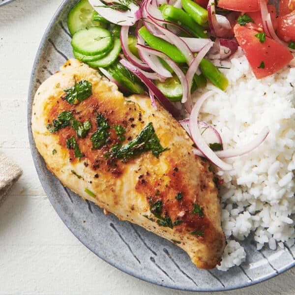 Cilantro lime chicken on plate with rice and salad.