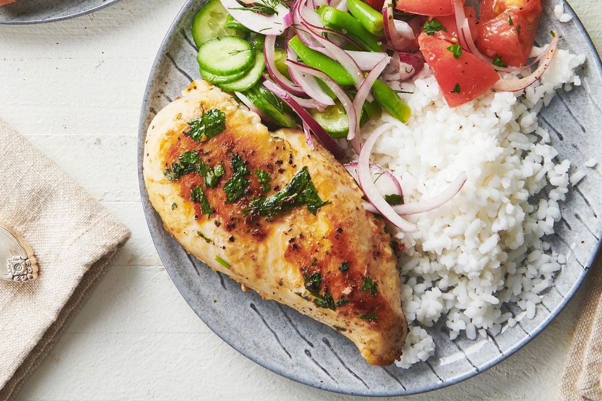 Cilantro lime chicken on plate with rice and salad.