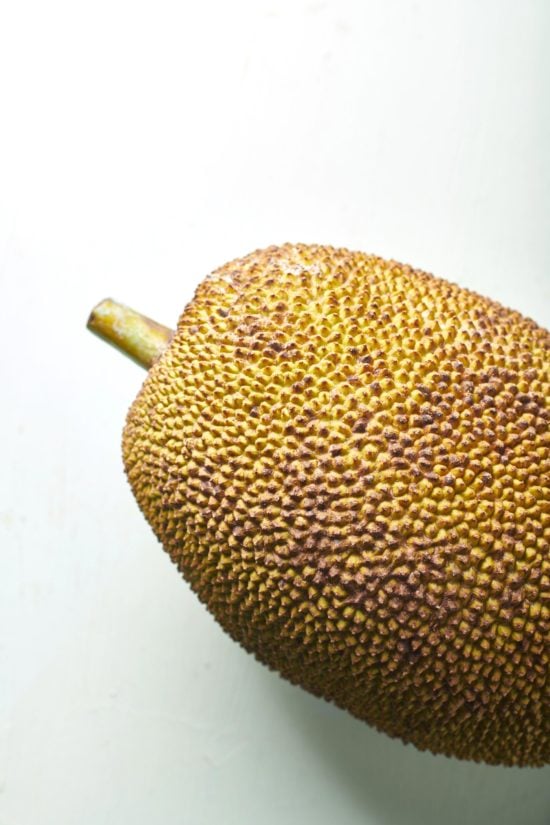 Whole jackfruit on a white table.