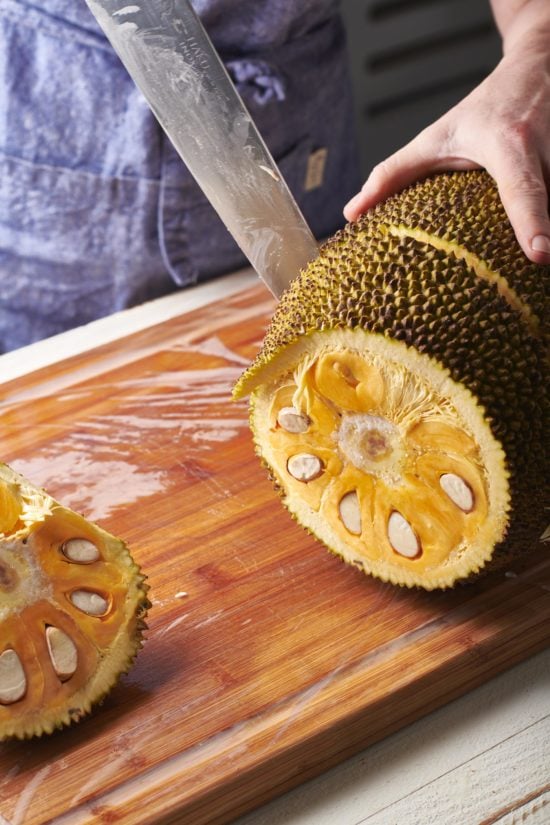 Woman slicing a jackfruit.