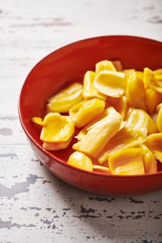 Red bowl of jackfruit pods.