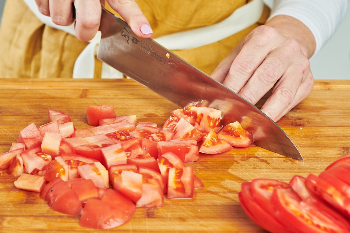 Dicing tomatoes with knife.