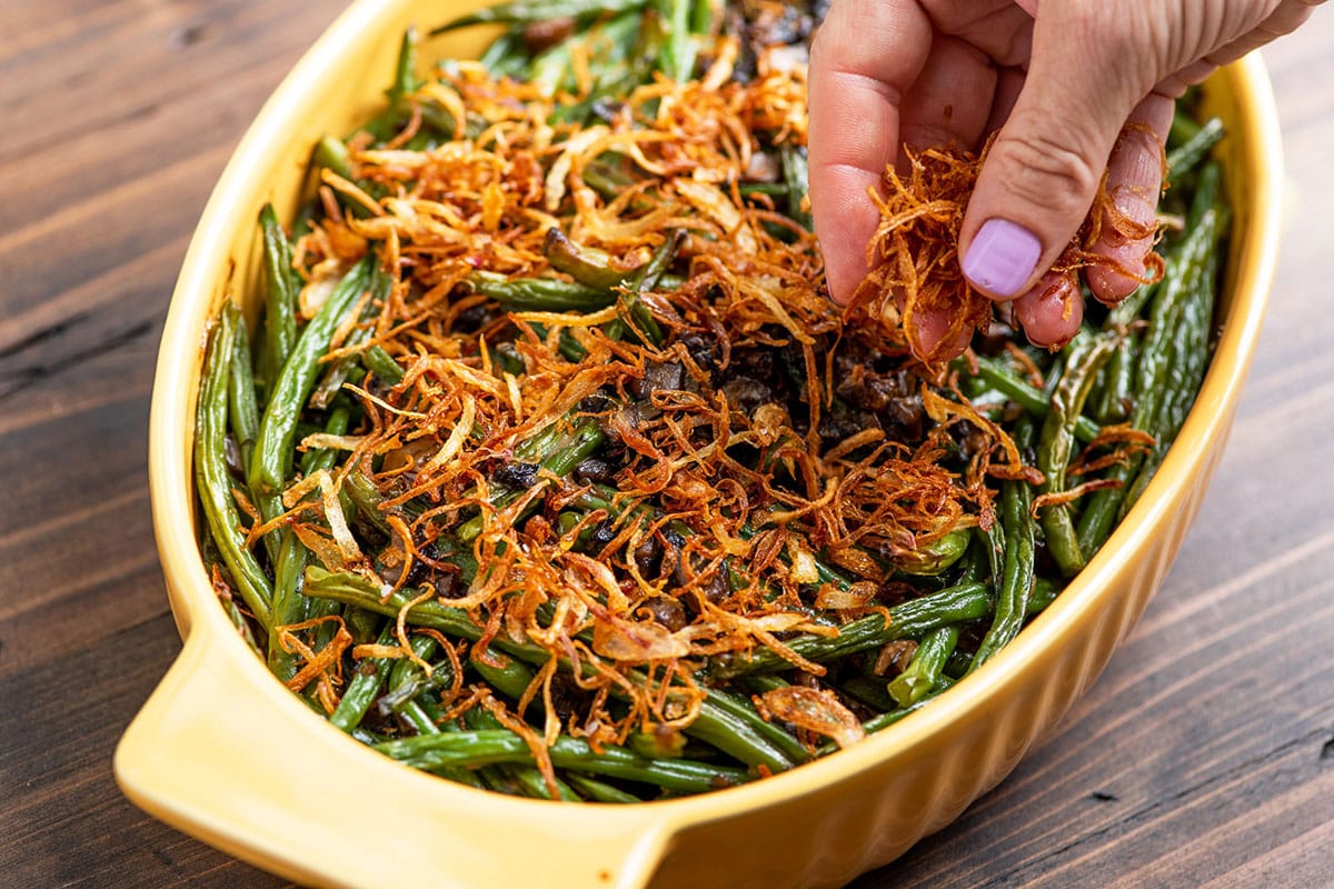 Sprinkling crispy shallots over Fresh Green Bean Casserole.