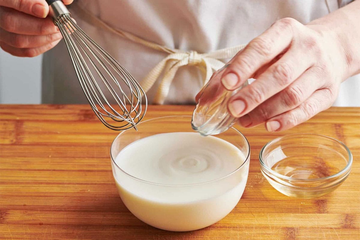 Whisking vinegar into milk to make buttermilk