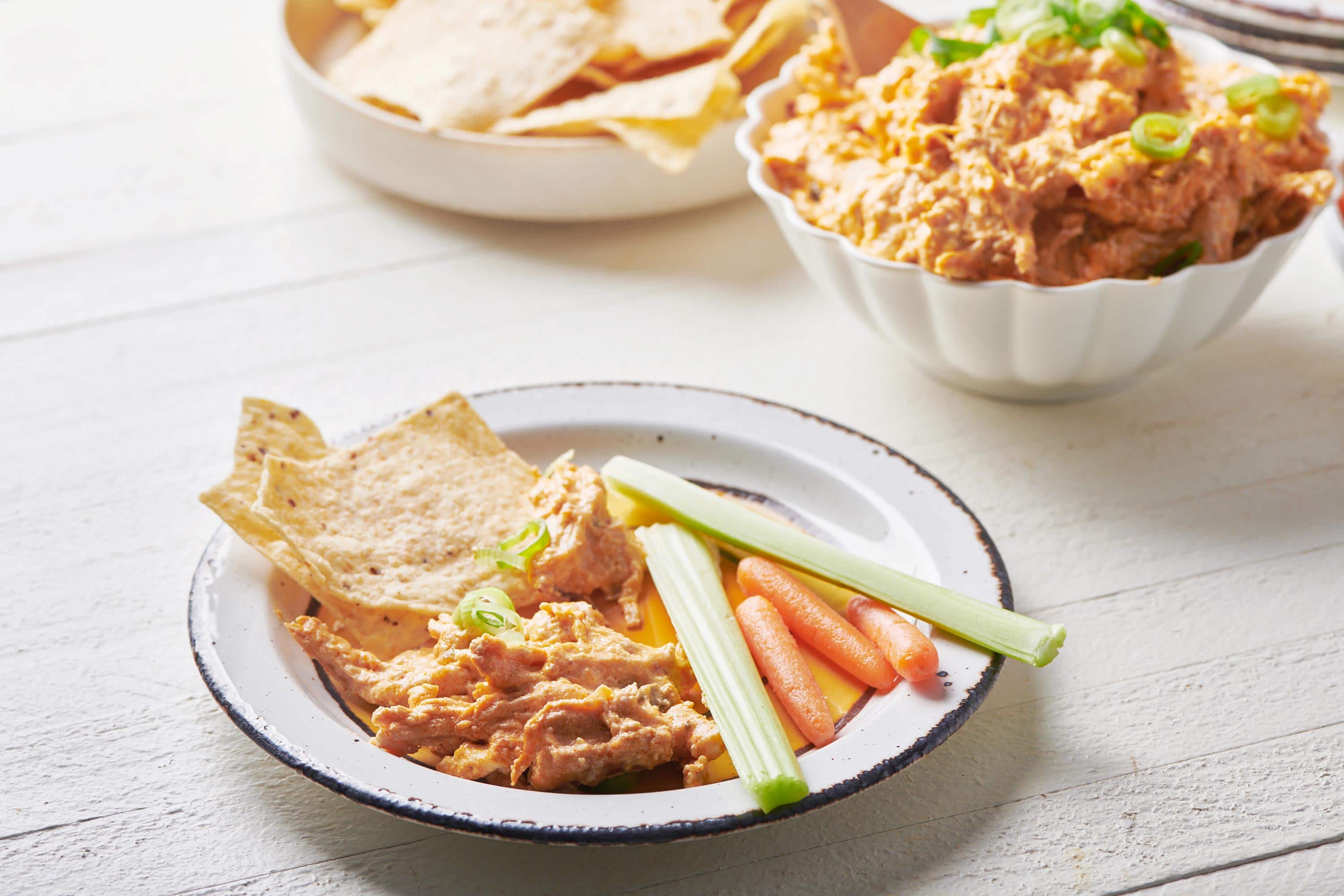 Carrots, celery, and chips on a plate with Buffalo Chicken Dip.