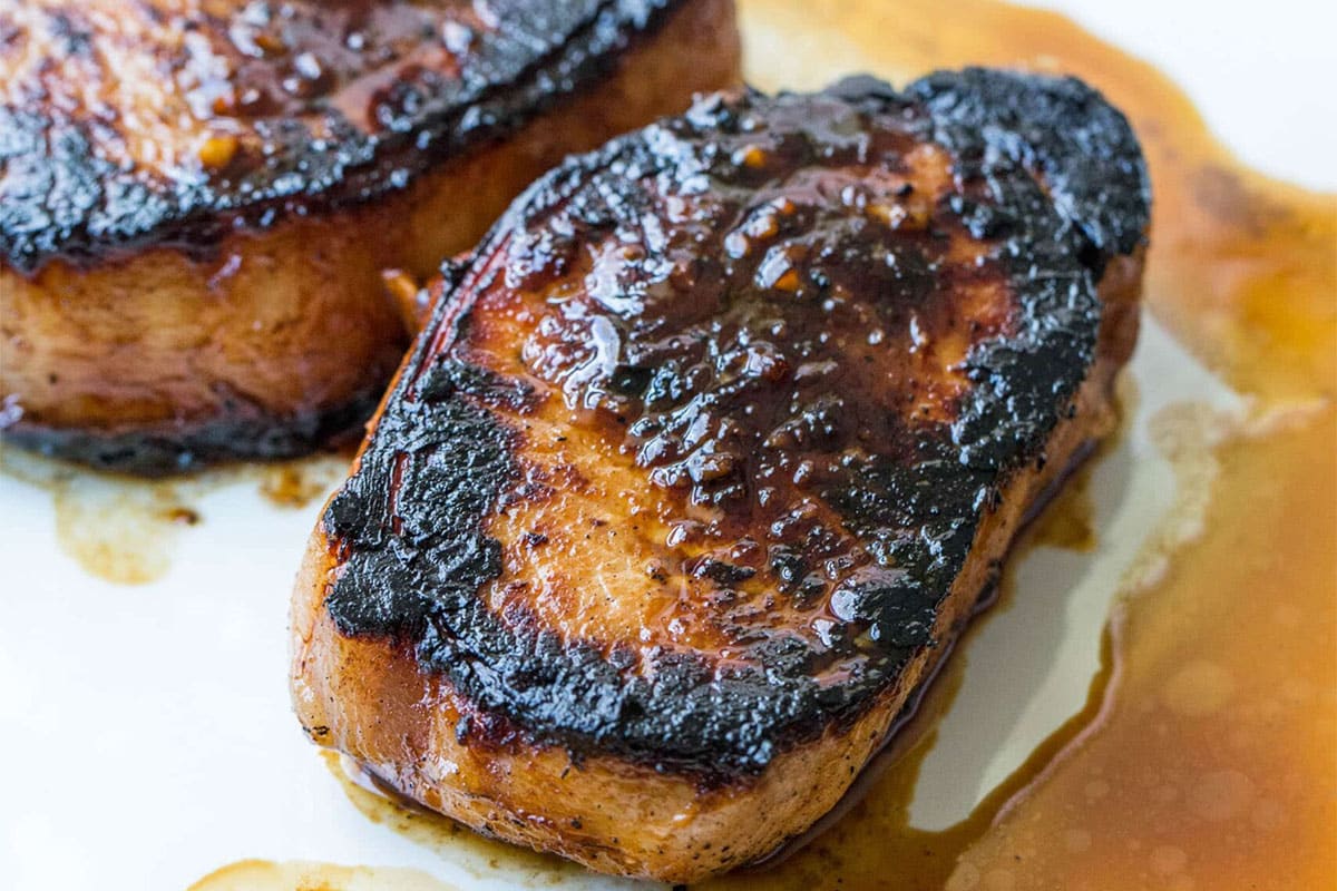 Korean marinated pork chop on plate with sauce.