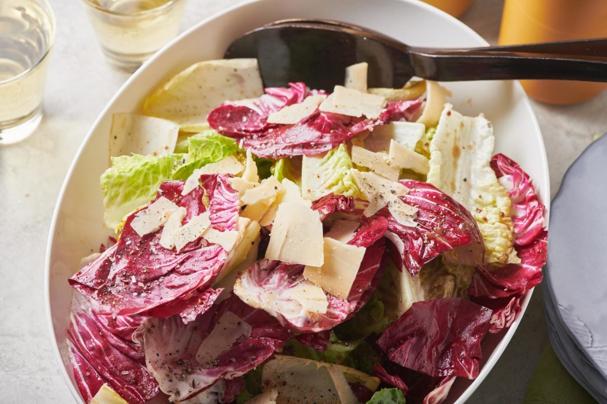 Spoon in a bowl of Mixed Lettuce Salad with Mustard Vinaigrette.