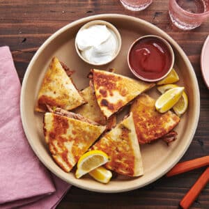 Tray of Pulled Pork Quesadillas, dips, and lemon wedges.