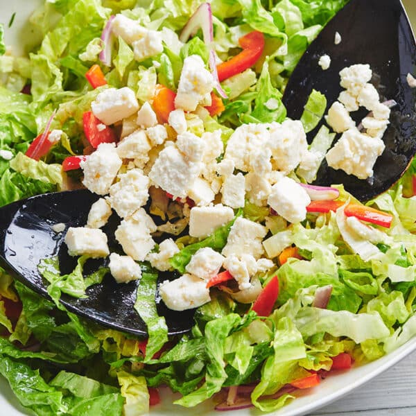 Two spoons in a bowl of Romaine Salad with Queso Fresco.