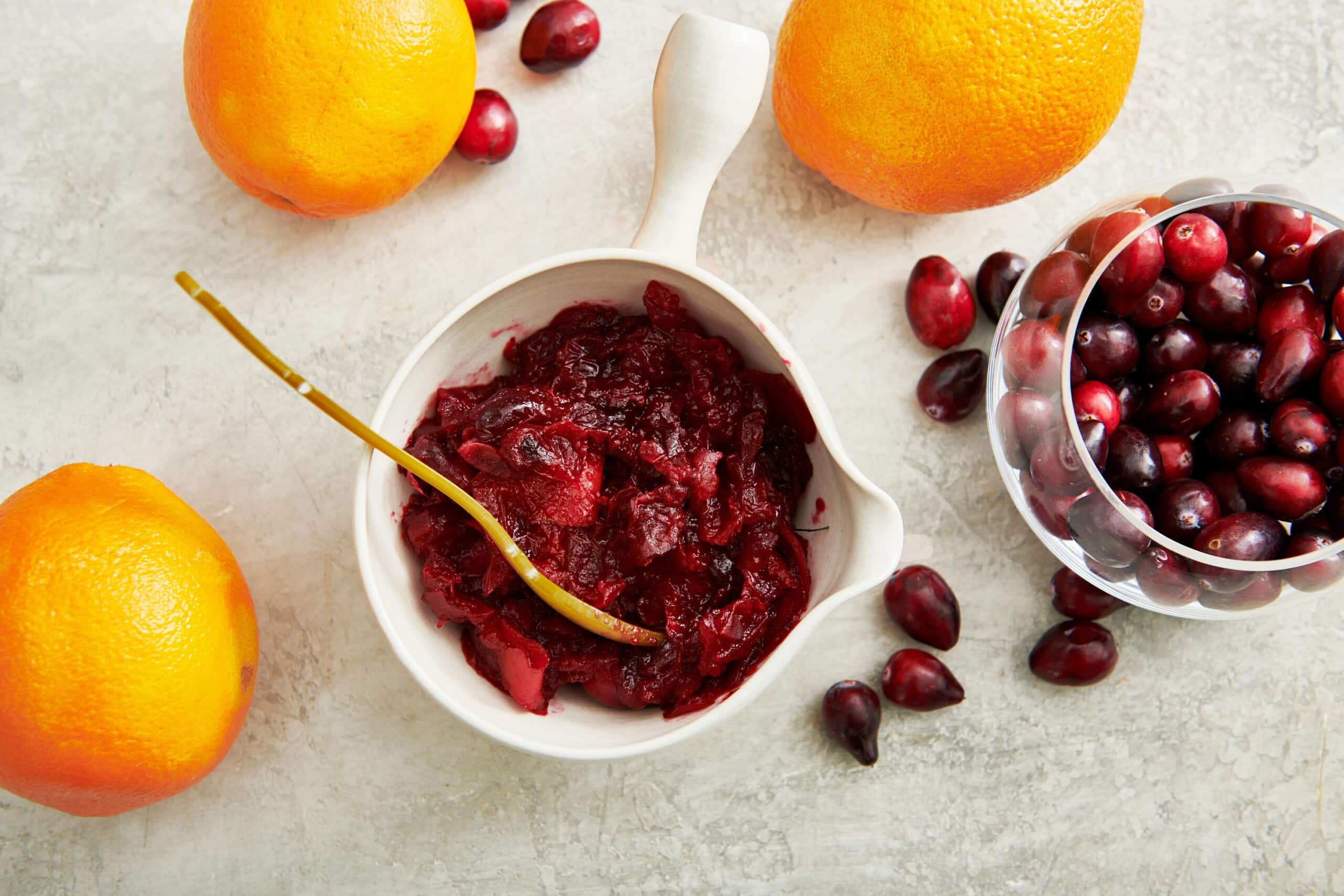 Cranberry Orange Sauce in bowls on table with oranges