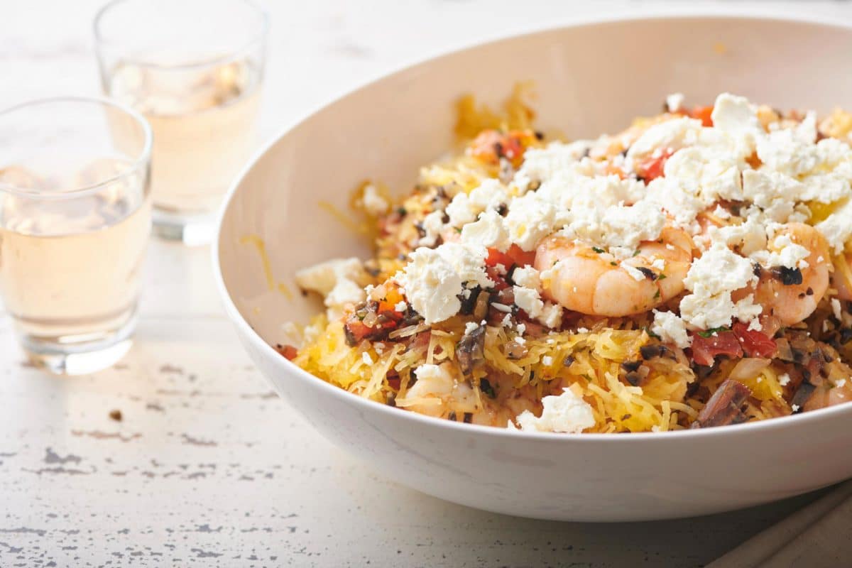 Bowl of Greek-Style Spaghetti Squash with Shrimp topped with feta cheese.