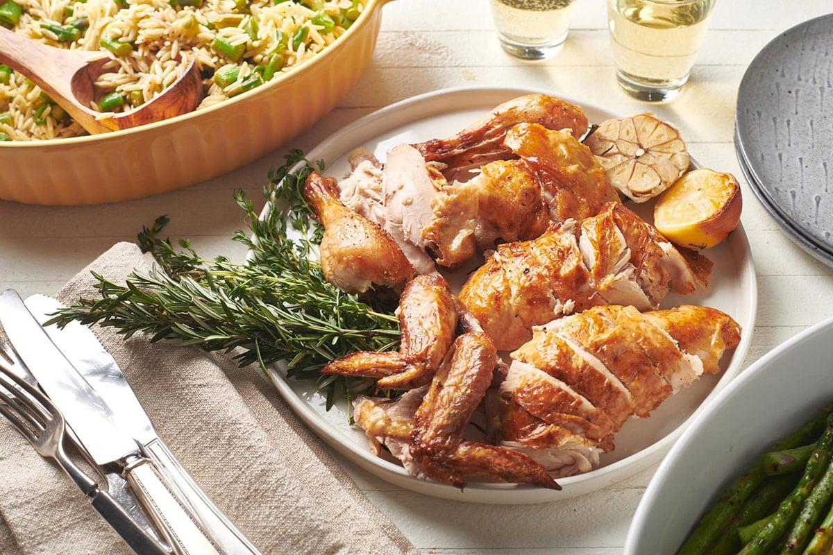 Roast Chicken pieces on serving platter with fresh herbs.