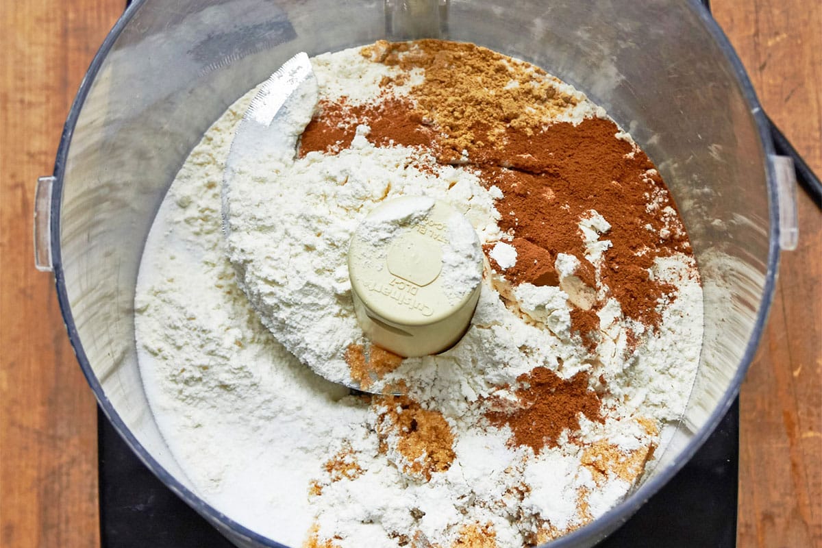 Flour, cinnamon, and other streusel ingredients in food processor bowl.
