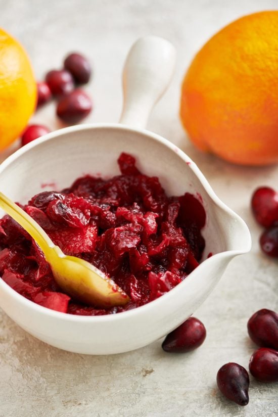 Spoon in a small bowl of Cranberry Orange Sauce.