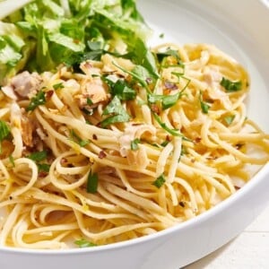 Linguine with White Clam Sauce in white bowl with salad.