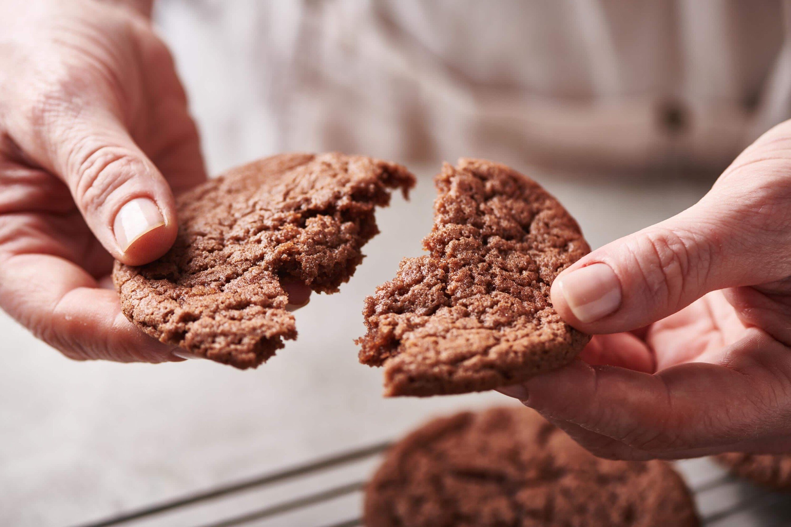 Woman pulling a Mexican Hot Chocolate Cookie apart.