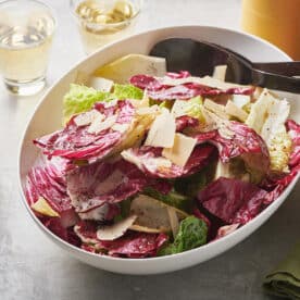 Spoon in a bowl of Mixed Lettuce Salad with Mustard Vinaigrette.