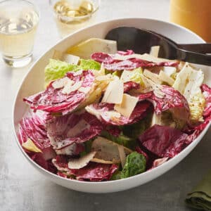 Spoon in a bowl of Mixed Lettuce Salad with Mustard Vinaigrette.