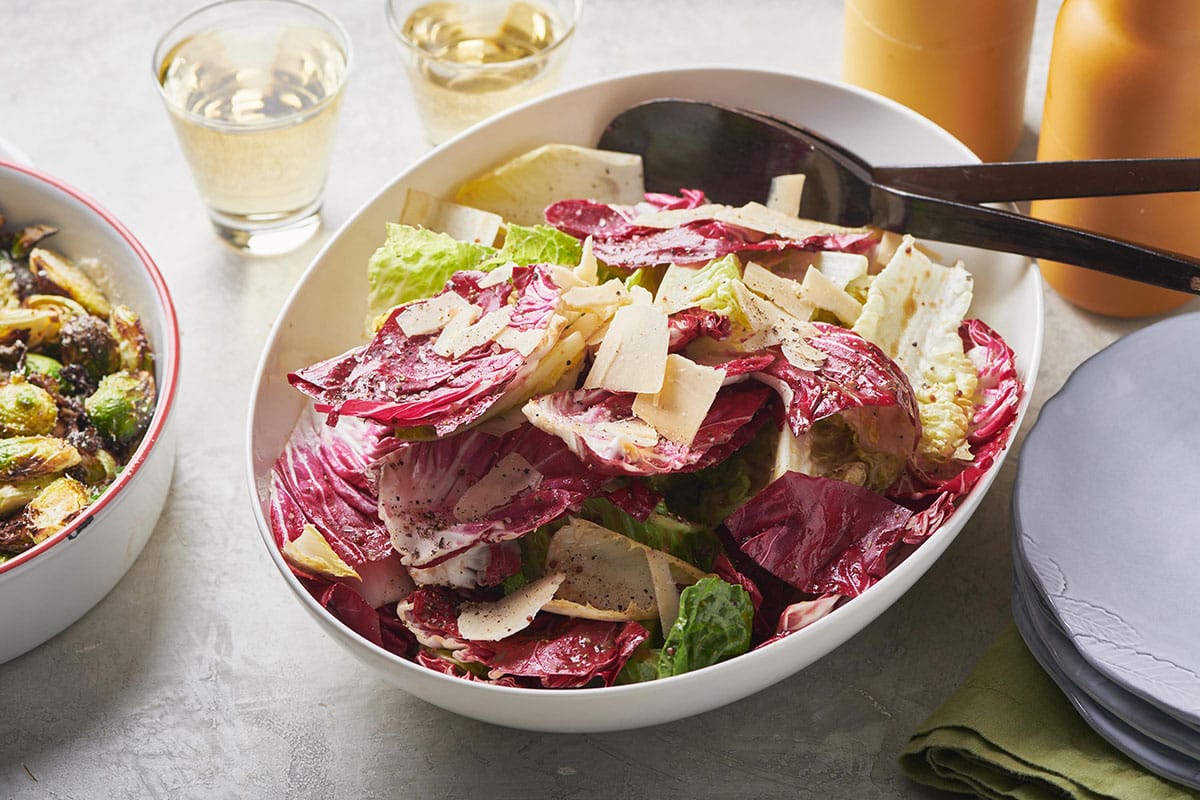 Spoon in a bowl of Mixed Lettuce Salad with Mustard Vinaigrette.