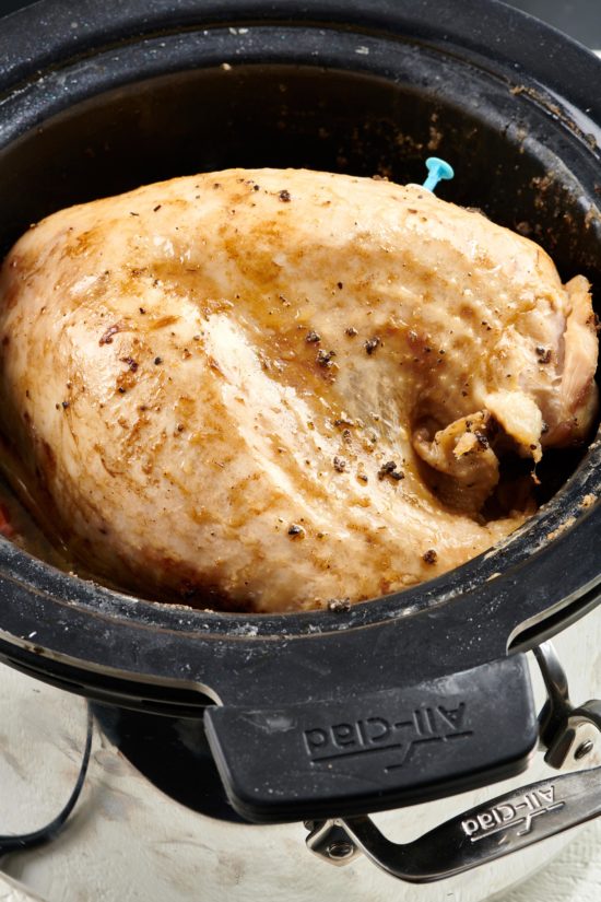 Seasoned turkey breast in a slow cooker.