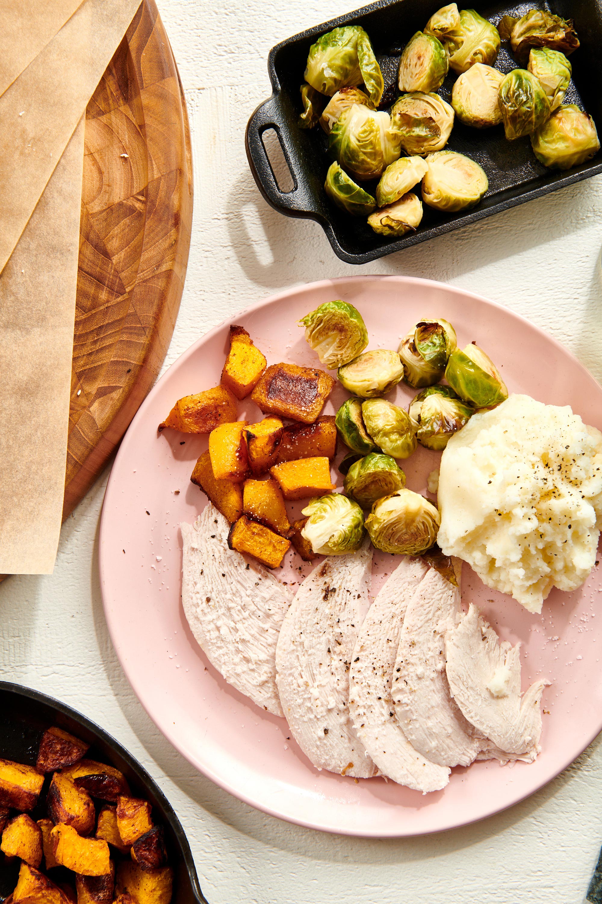 Slow Cooker Turkey Breast with Brussels sprouts and butternut squash on a pink plate.