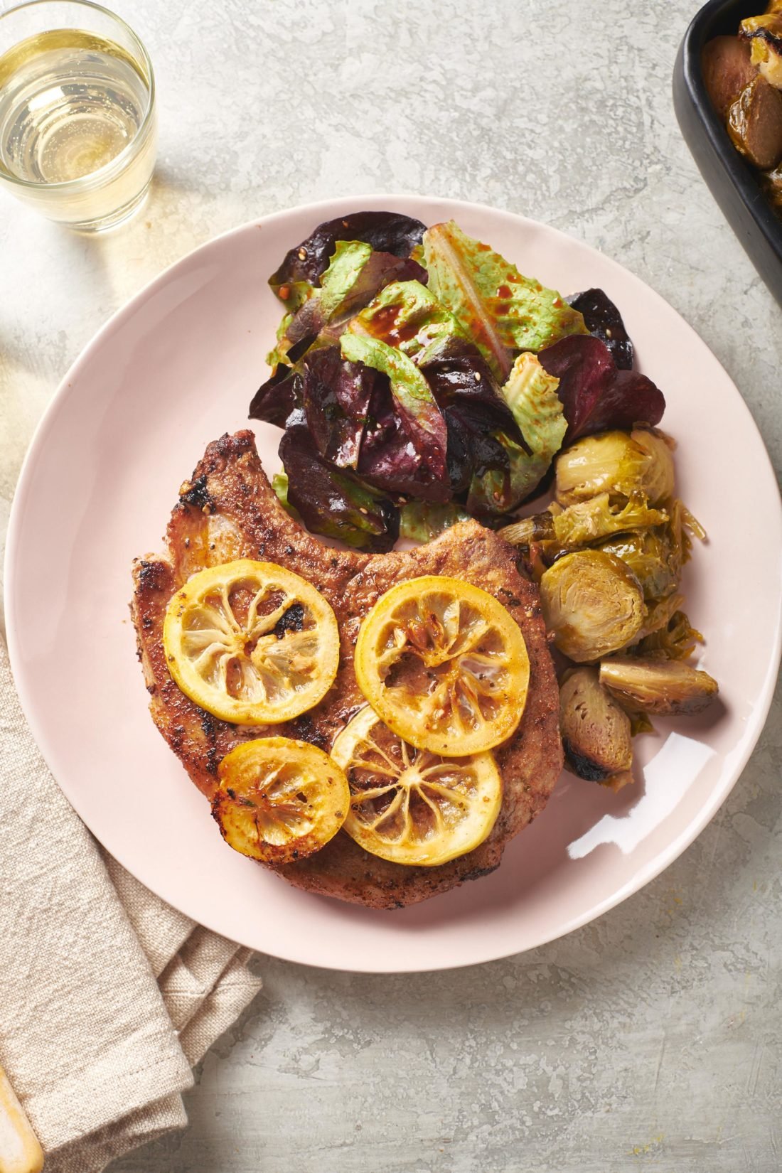 Plate with a Spanish Pork Chop, brussels sprouts, and salad.