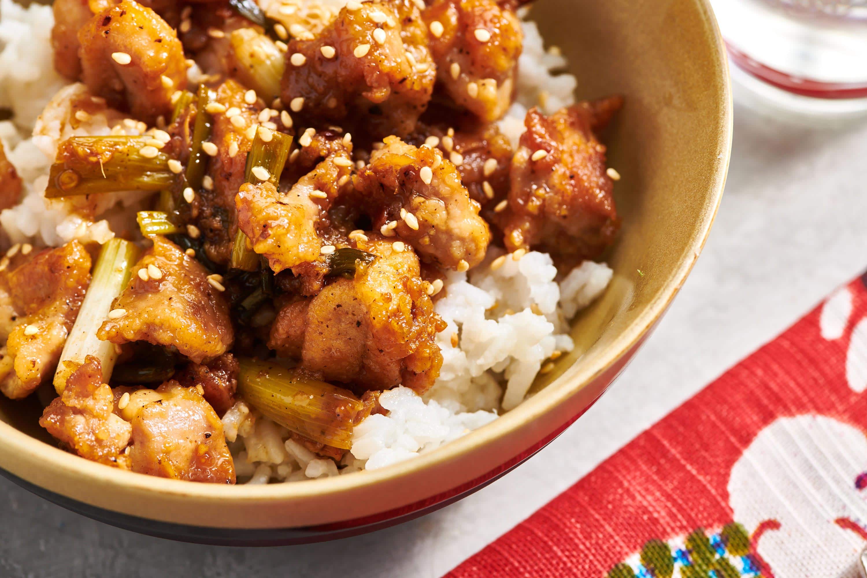 General Tso's Chicken over rice in brown bowl.