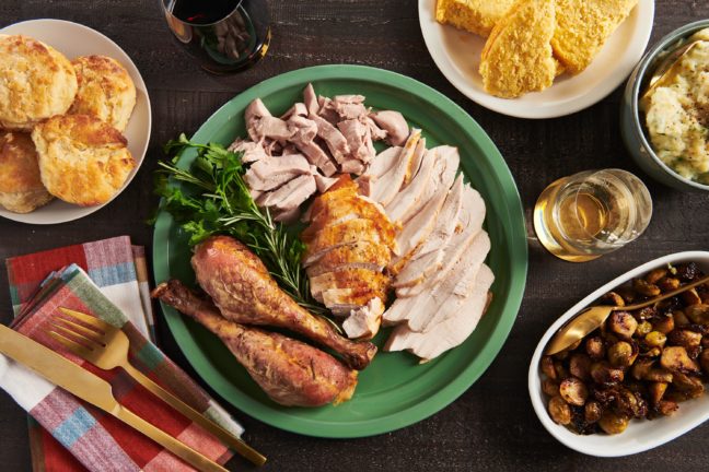 Plate of Roasted Thanksgiving Turkey on a table with Thanksgiving sides.