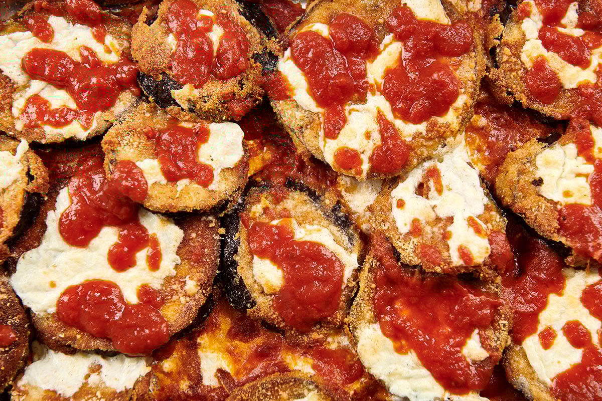 Pile of Crispy Baked Eggplant Parmesan with marinara sauce.