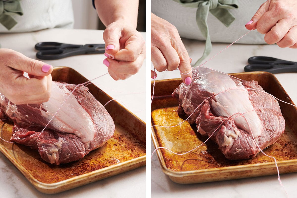 Tying beef tenderloin with twine on baking sheet.
