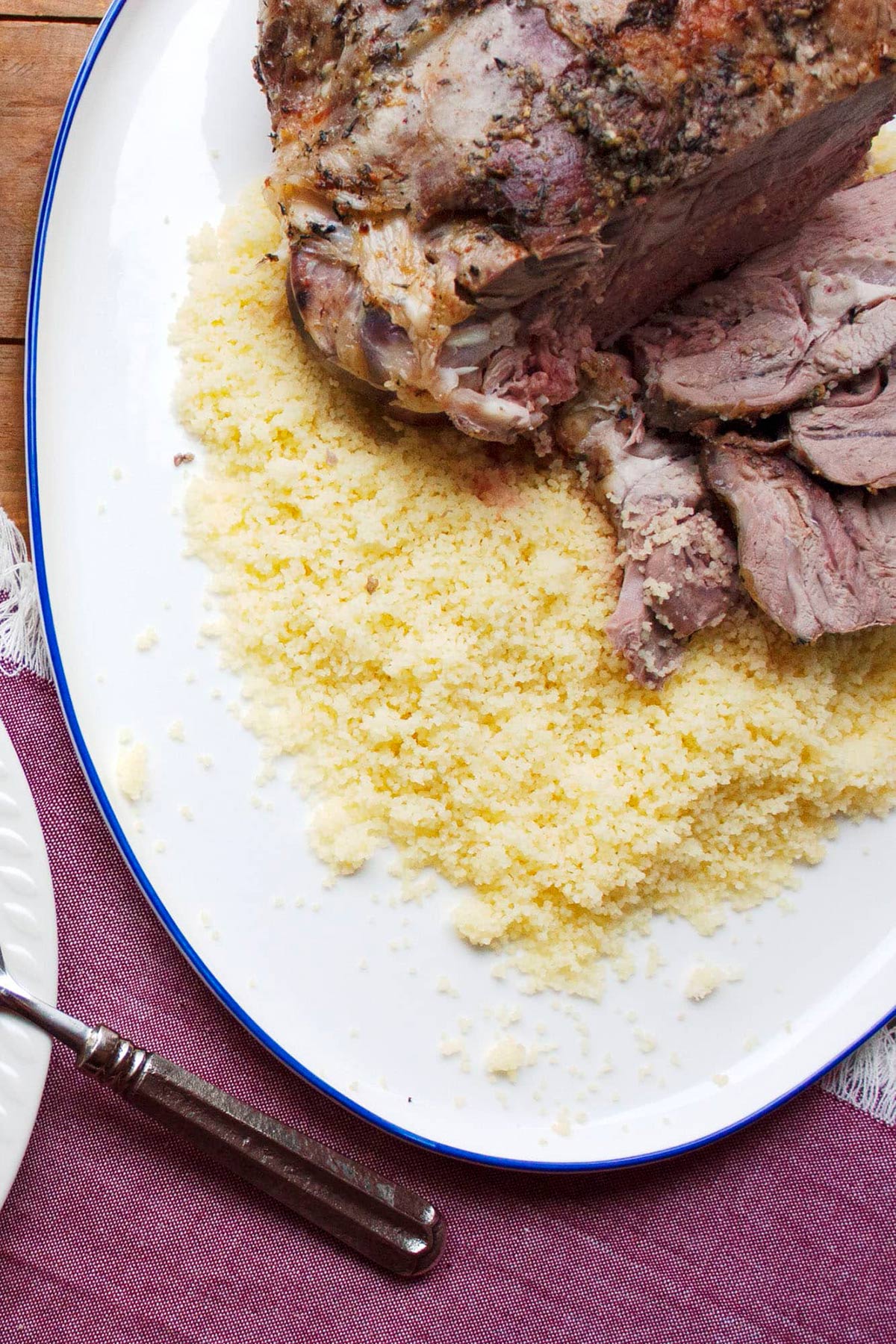 Mediterranean Leg of Lamb on a platter with couscous.