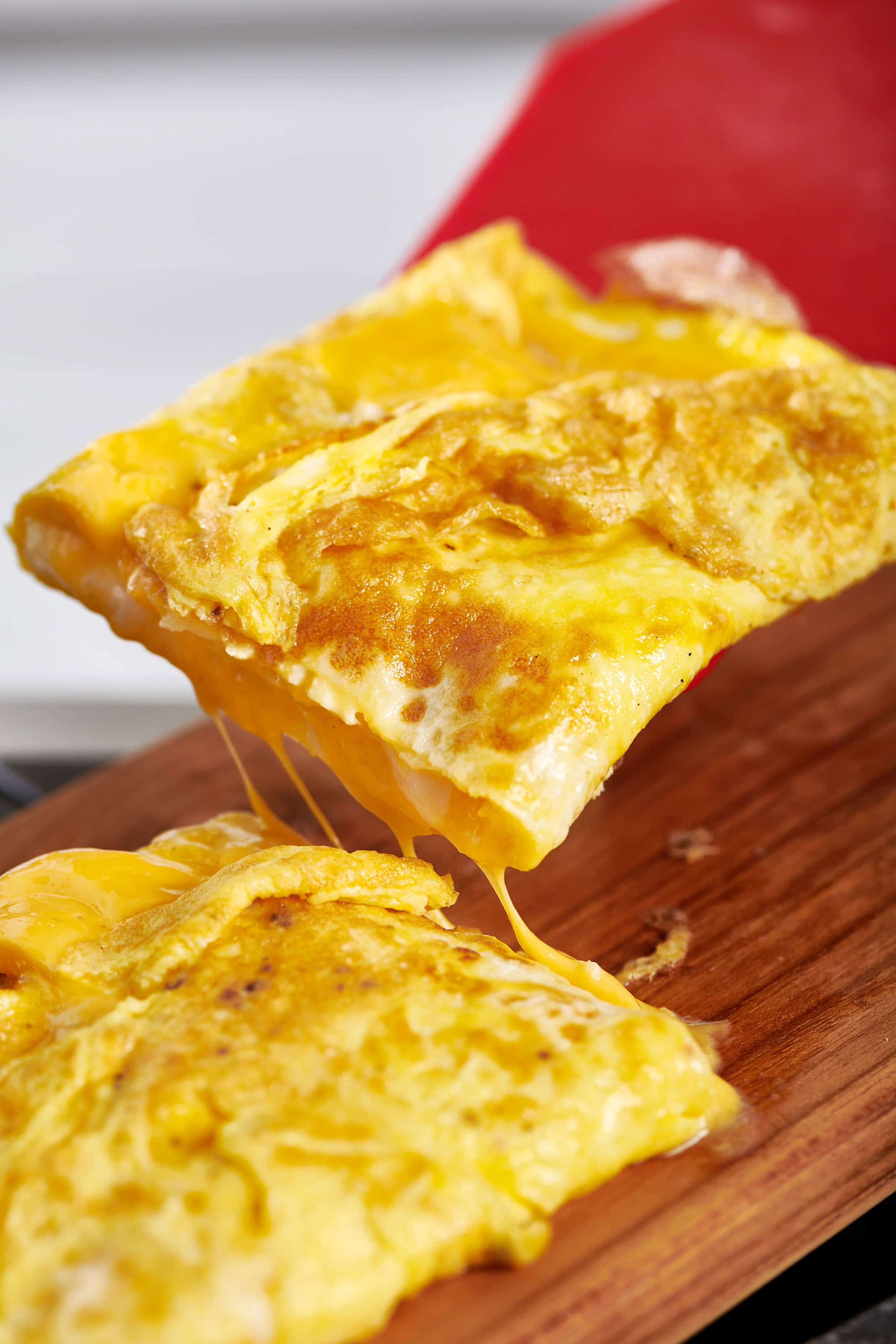 Cheesy eggs on a wooden board.