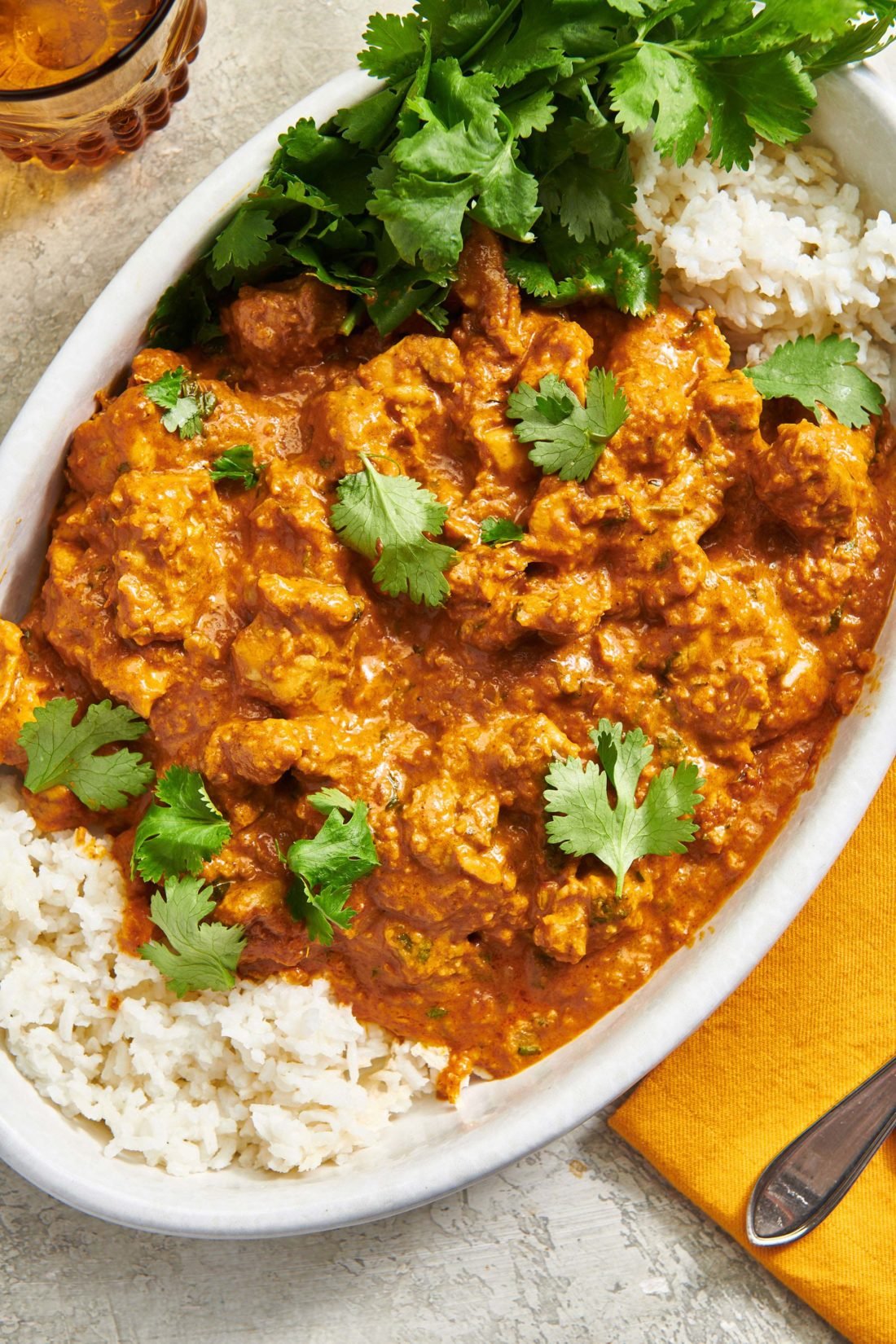 Butter Chicken (Murgh Makhani) and rice in a dish.