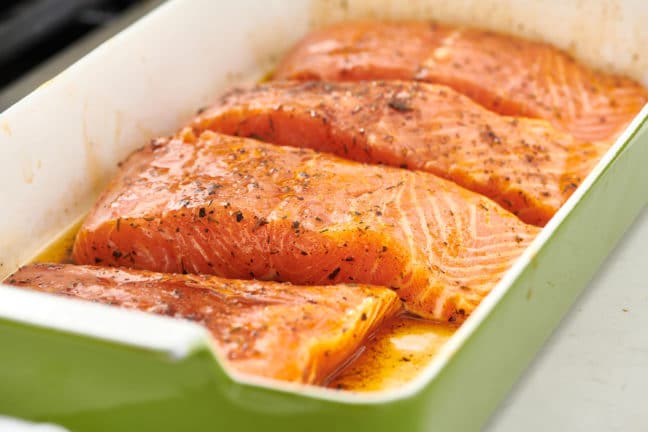 Seasoned Salmon in a green baking dish.