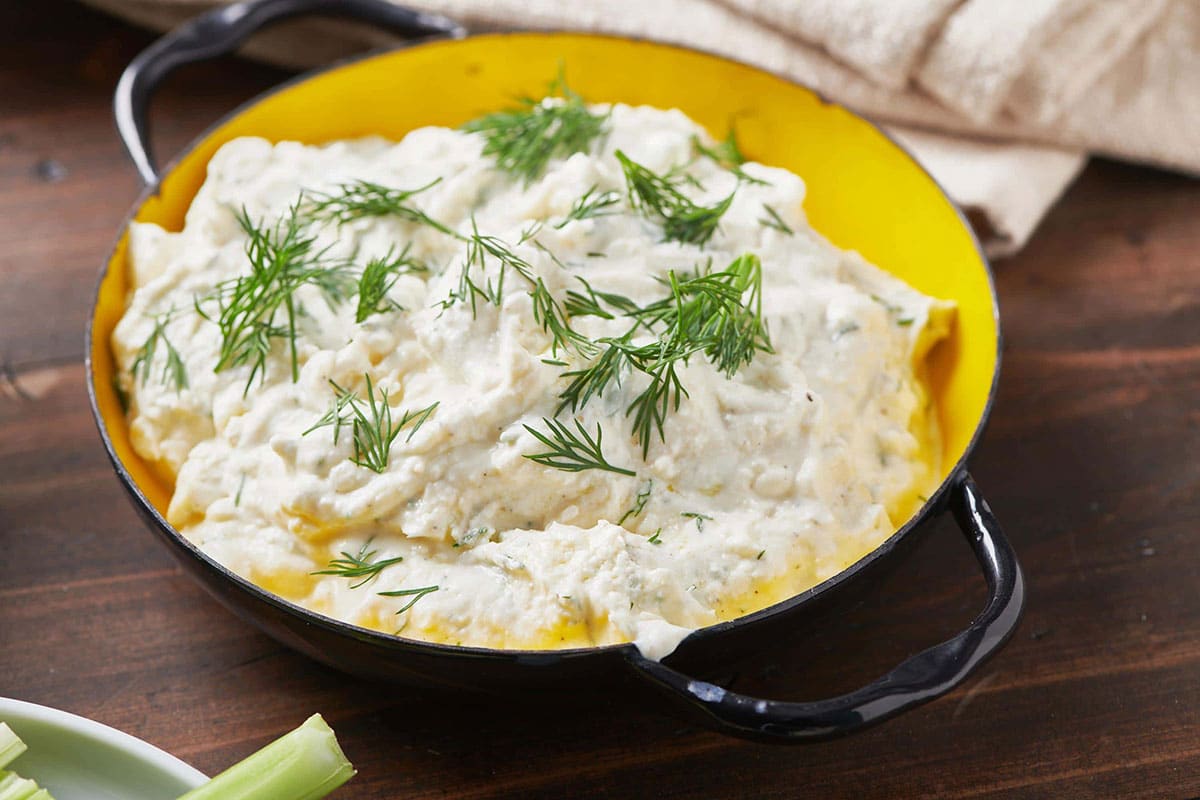 Feta Yogurt Dip with fresh dill in bowl on table.
