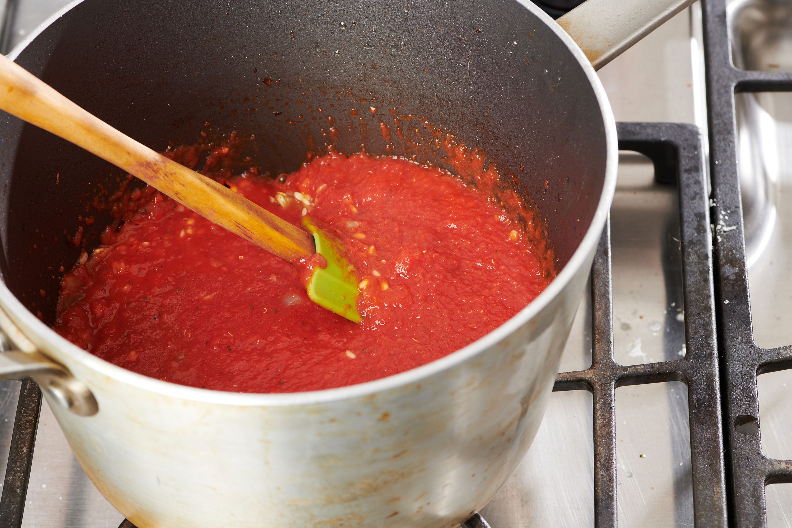 Tomato mixture cooking in saucepan.