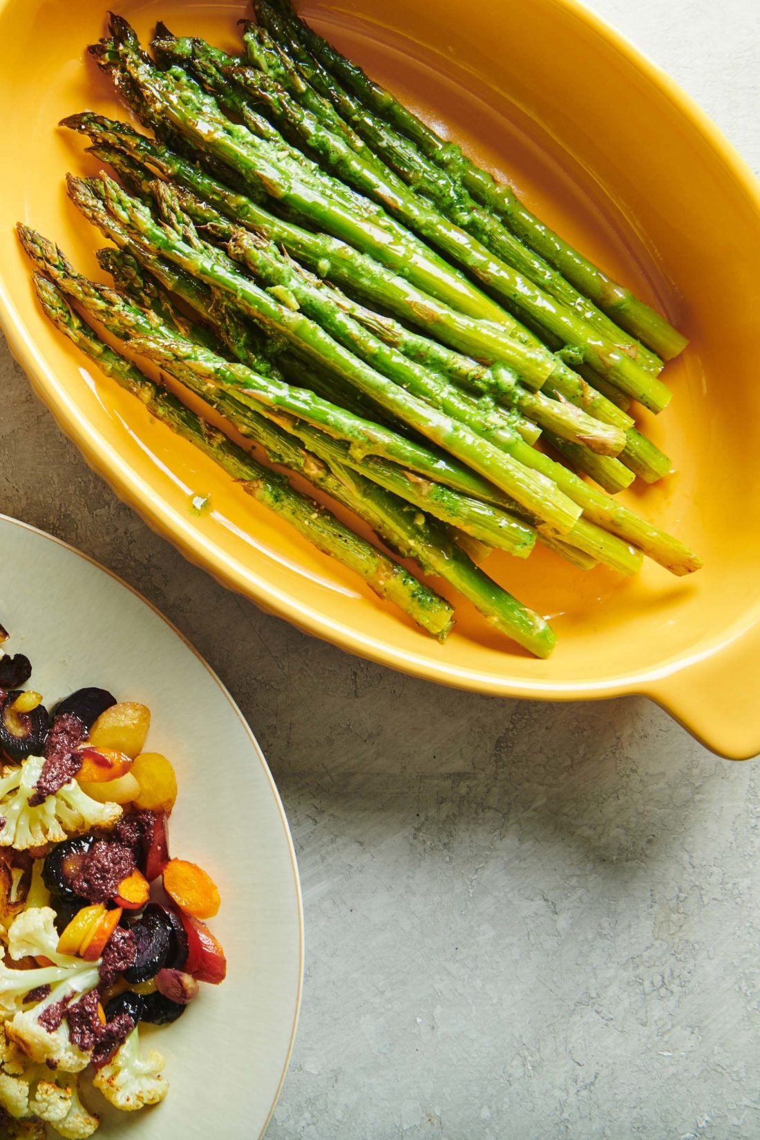 Roasted Asparagus with Pesto Crème Fraiche in a yellow serving dish.