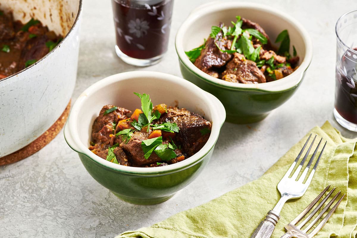 Two green bowls of Beef Stew on a table.