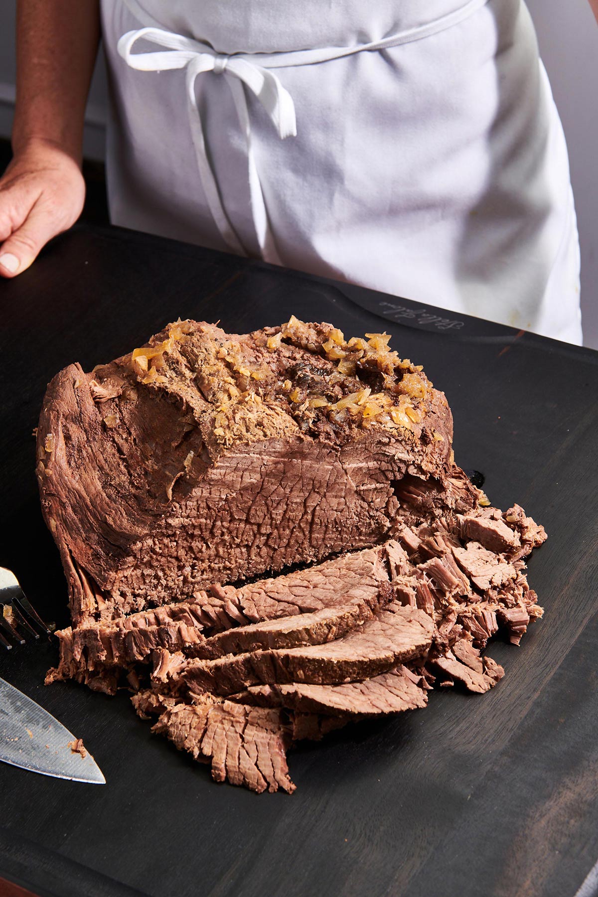 Sliced Slow Cooker Pot Roast on cutting board.