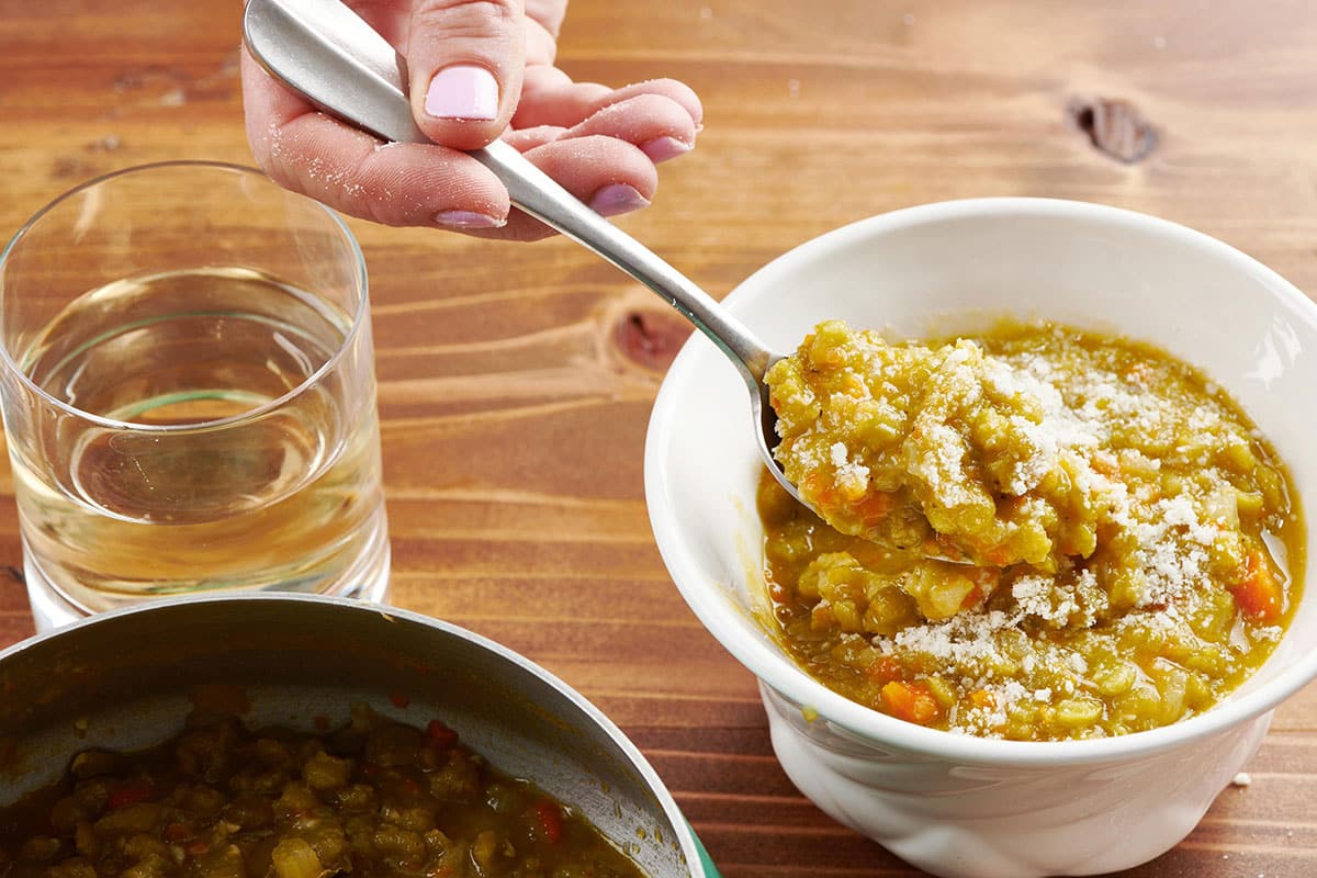 Dishing vegetarian split pea soup from bowl. 
