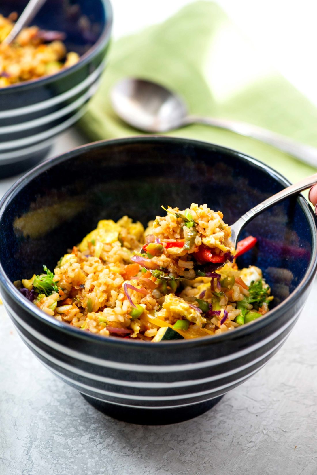 Fork scooping Vegetable Stir Fried Rice from a bowl.
